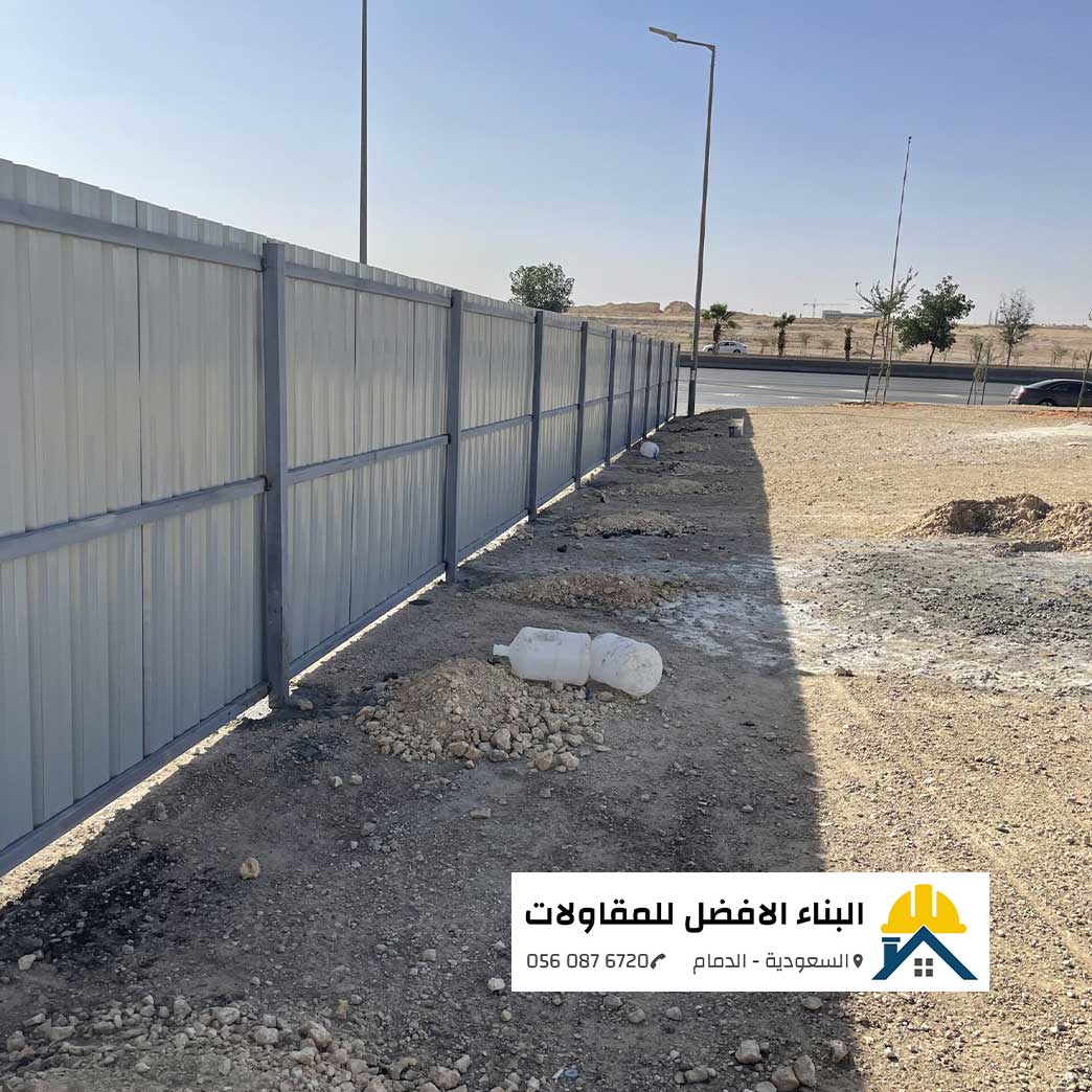 الرئيسية - البناء الافضل للمقاولات سياج وألواح شينكو معدنية رمادية اللون مثبتة على هيكل وقواعد حديدية قوية لتحديد وتسوير موقع بناء أو أرض فضاء على جانب الطريق، من تنفيذ مؤسسة البناء الأفضل للمقاولات بالدمام مع الشعار ورقم الاتصال 0560876720.