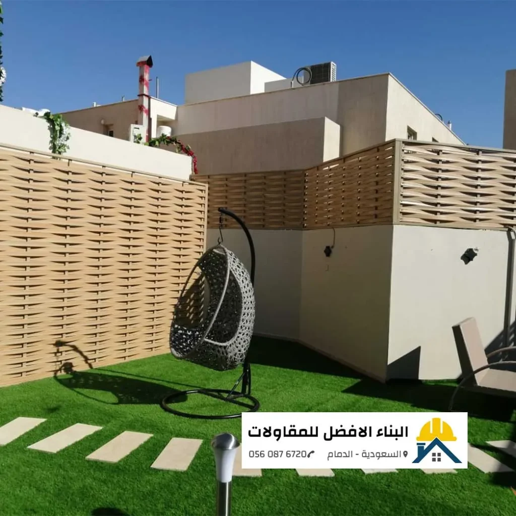 سواتر خشبية عصرية مجدولة على أسوار حديقة منزلية مع مسطحات خضراء في الدمام، تنفيذ مؤسسة البناء الأفضل للمقاولات.
