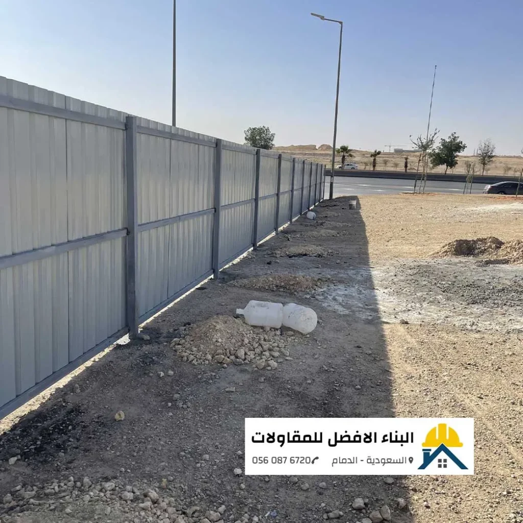 سور شينكو مضلع بلون أبيض مثبت على هيكل حديدي رمادي ممتد لتسييج وتحويش أرض فضاء بيضاء على جانب طريق رئيسي، من أعمال مقاول تحويشات بمؤسسة البناء الأفضل للمقاولات بالدمام 0560876720.