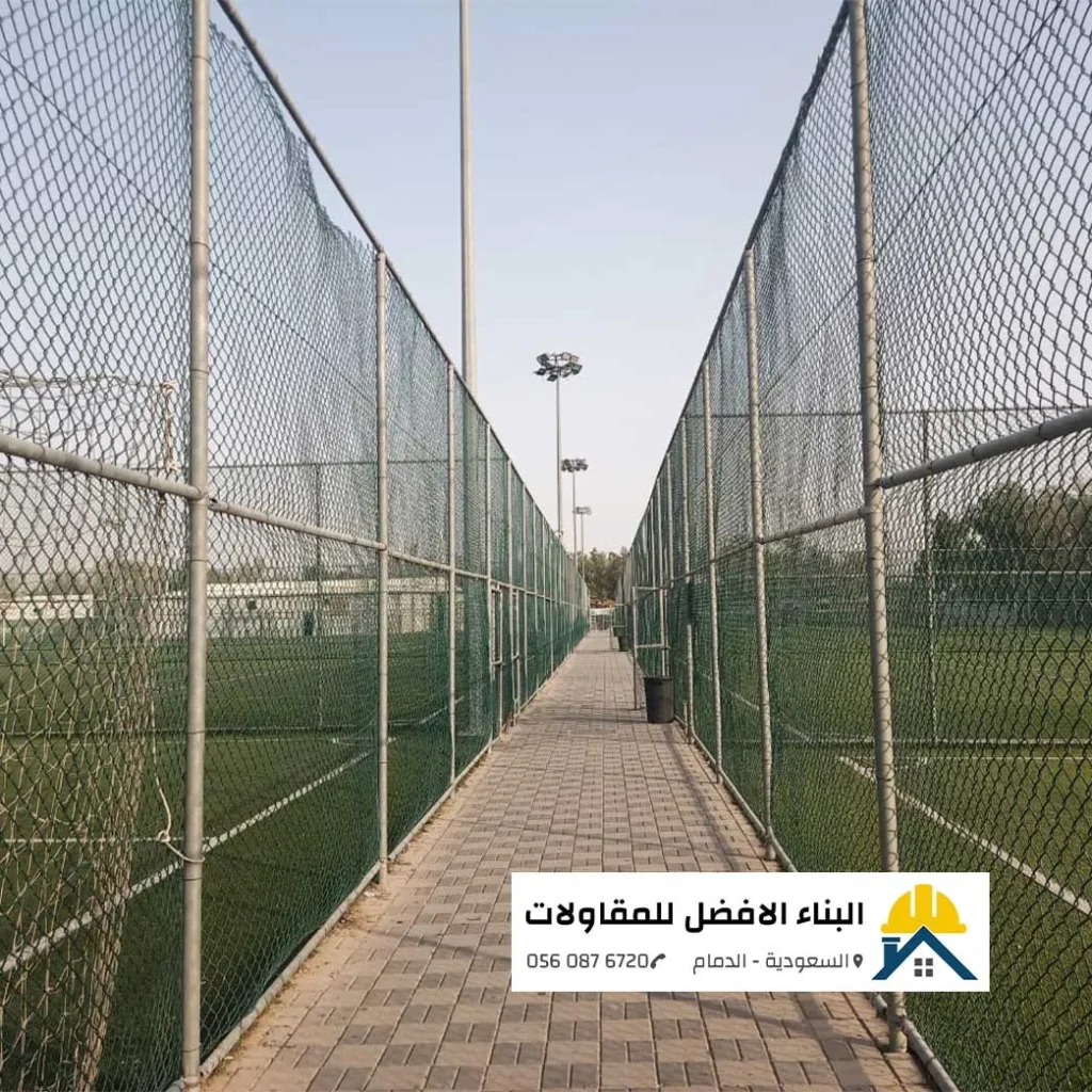 سياج شبكي متين باللون الأخضر مجهز ببوابة مدمجة ومثبت على ميدة خرسانية أرضية يحوط مزرعة نخيل خضراء، من أعمال تركيب الشبوك الدمام بمؤسسة البناء الأفضل للمقاولات 0560876720.