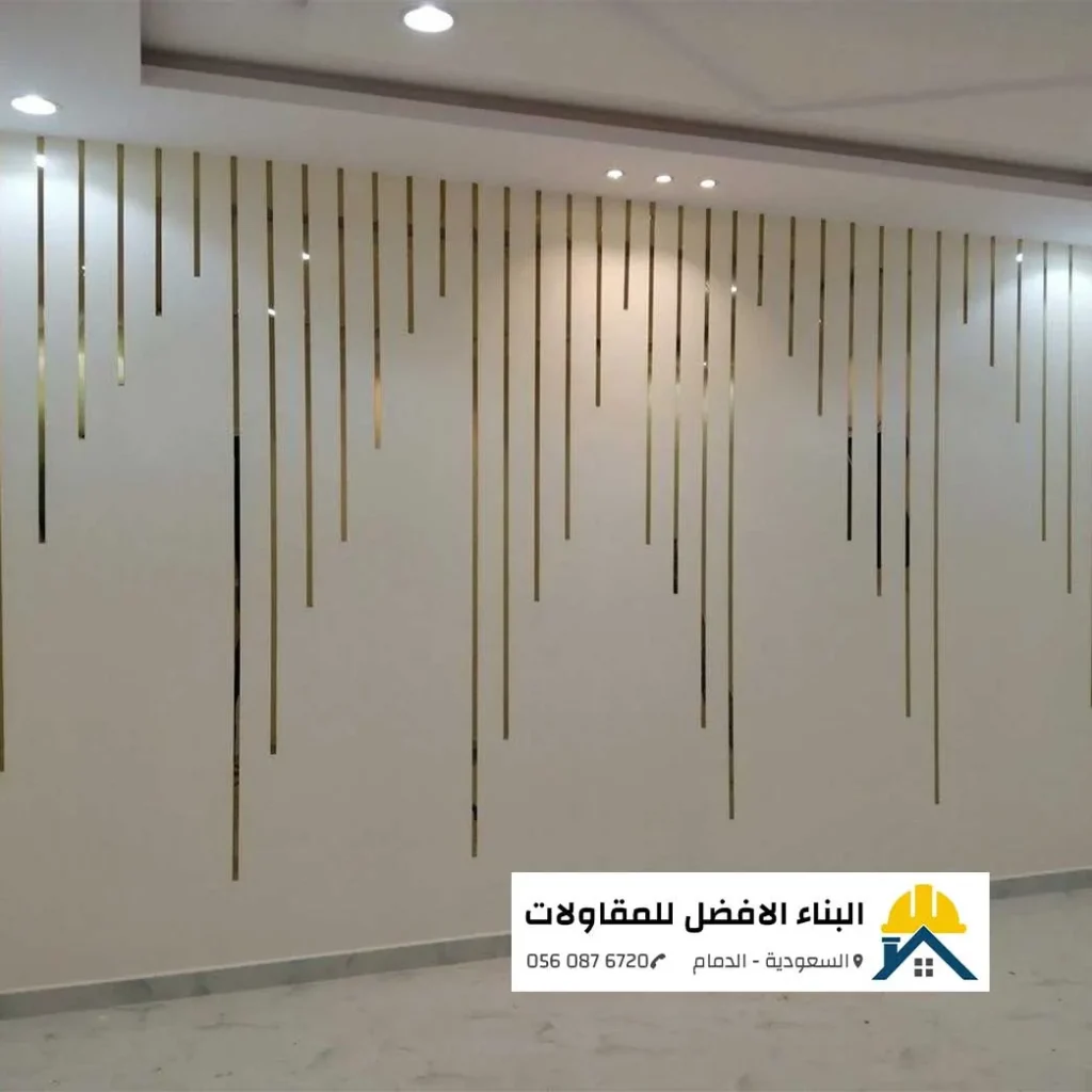 ديكورات جدران داخلية عصرية مزودة بخطوط معدنية مذهبة نازلة من السقف في صالة بالدمام، تنفيذ مؤسسة البناء الأفضل للمقاولات.