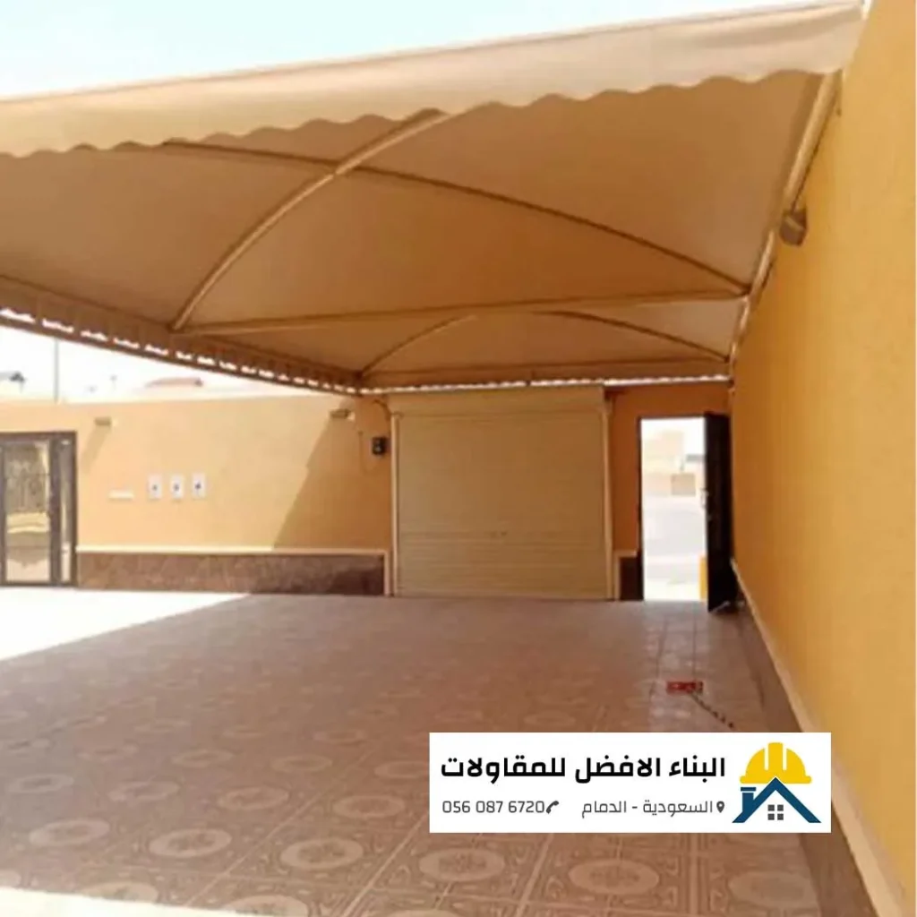 مظلة مواقف سيارات قماشية بيج بتصميم مقوس فوق ساحة خارجية لمنزل في الدمام، تنفيذ مؤسسة البناء الأفضل للمقاولات.