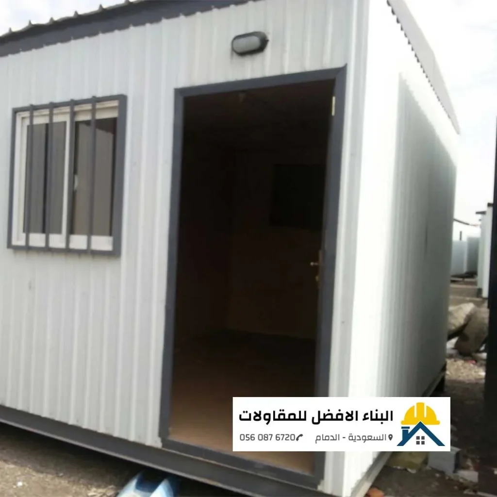 غرفة جاهزة أو غرفة سائق بتصميم عملي مع باب مفتوح ونافذة محمية بقضبان حديدية في الدمام، من مؤسسة البناء الأفضل للمقاولات.