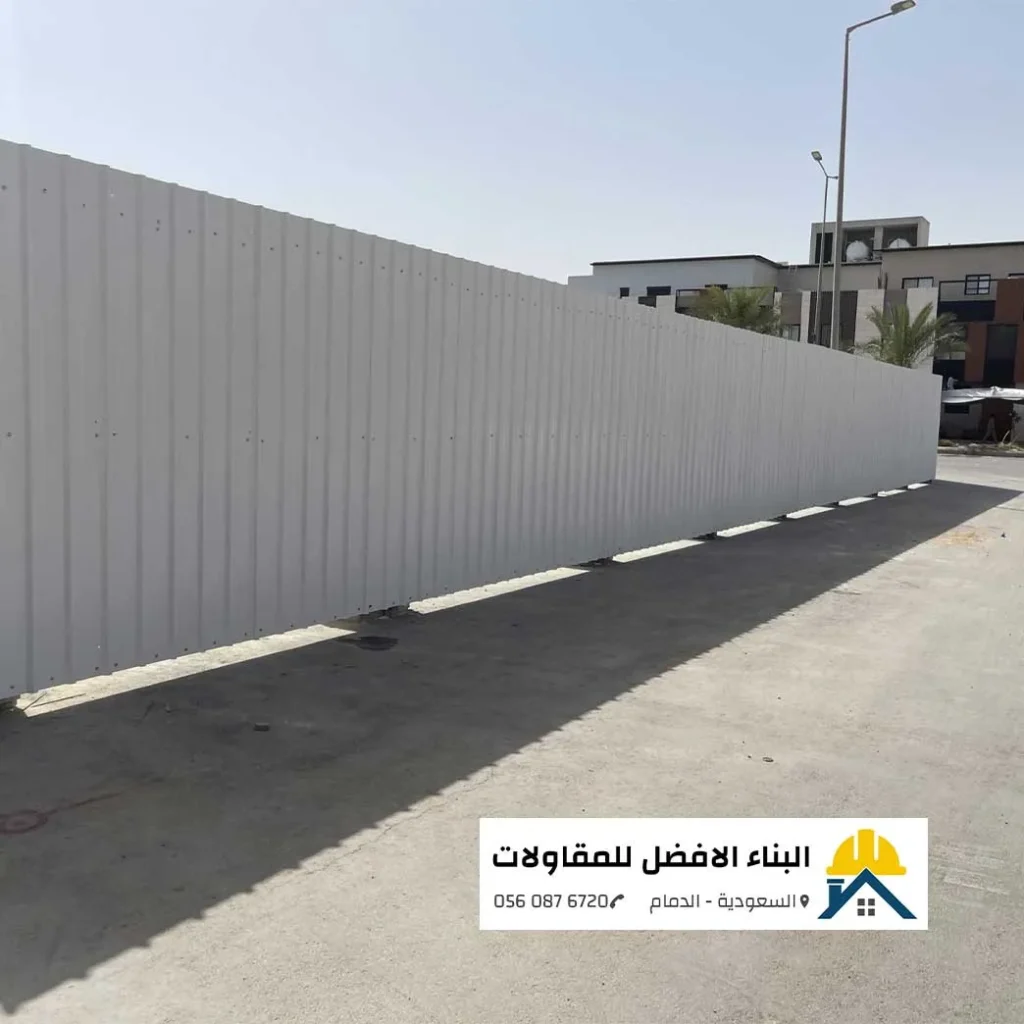 لقطة جانبية ممتدة لسور تحويش مؤقت مصنوع من ألواح الشينكو الأبيض المضلع لتأمين موقع إنشائي في حي سكني بالدمام، من تنفيذ مؤسسة البناء الأفضل للمقاولات 0560876720.