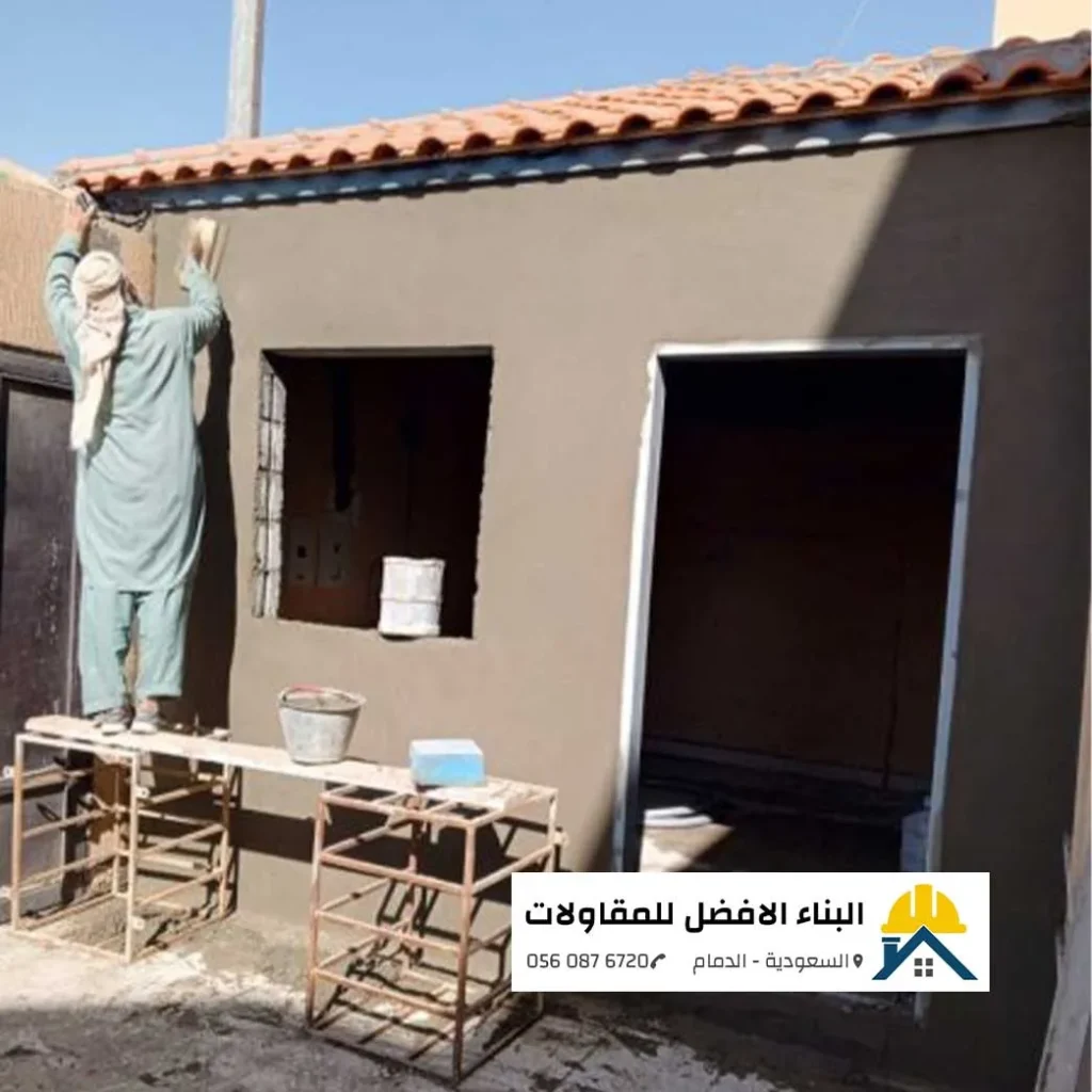 عامل لياسة يعمل على تلييس جدران ملحق خارجي قيد الإنشاء في الدمام، مع شعار مؤسسة البناء الأفضل للمقاولات.