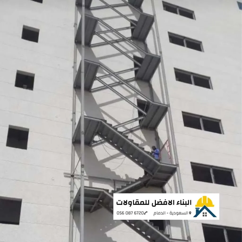 درج حديد خارجي متعدد الطوابق مخصص لمخارج الطوارئ مثبت على واجهة مبنى أبيض بالدمام، تنفيذ مؤسسة البناء الأفضل للمقاولات.