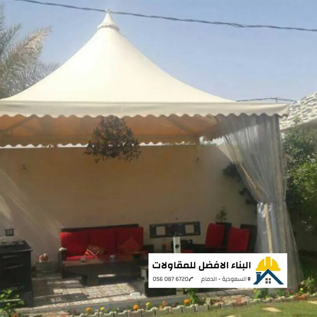 مظلة حديقة مخروطية بيج اللون تغطي جلسة خارجية بمسطحات خضراء في الدمام، تنفيذ مؤسسة البناء الأفضل للمقاولات.