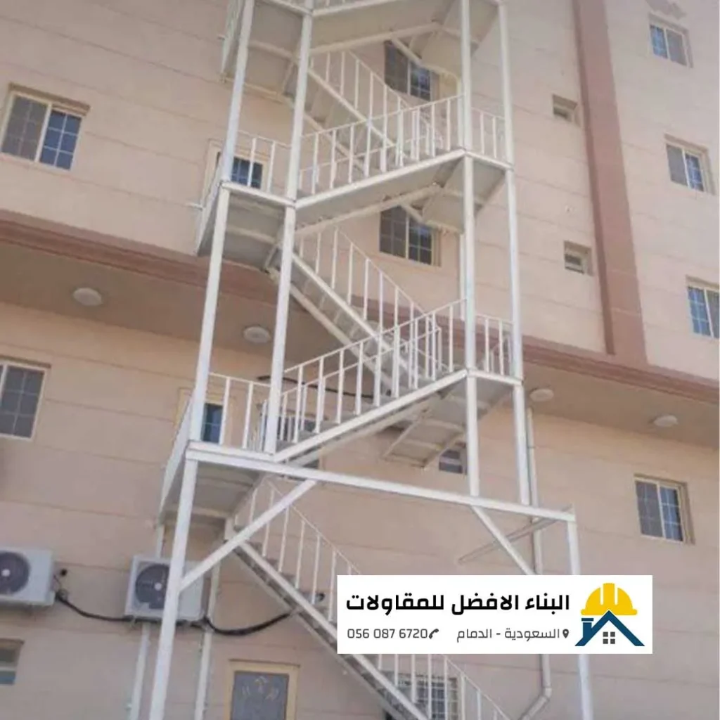 درج حديد خارجي أبيض اللون مخصص لمخارج الطوارئ ومثبت على واجهة مبنى بيج بالدمام، تنفيذ مؤسسة البناء الأفضل للمقاولات.